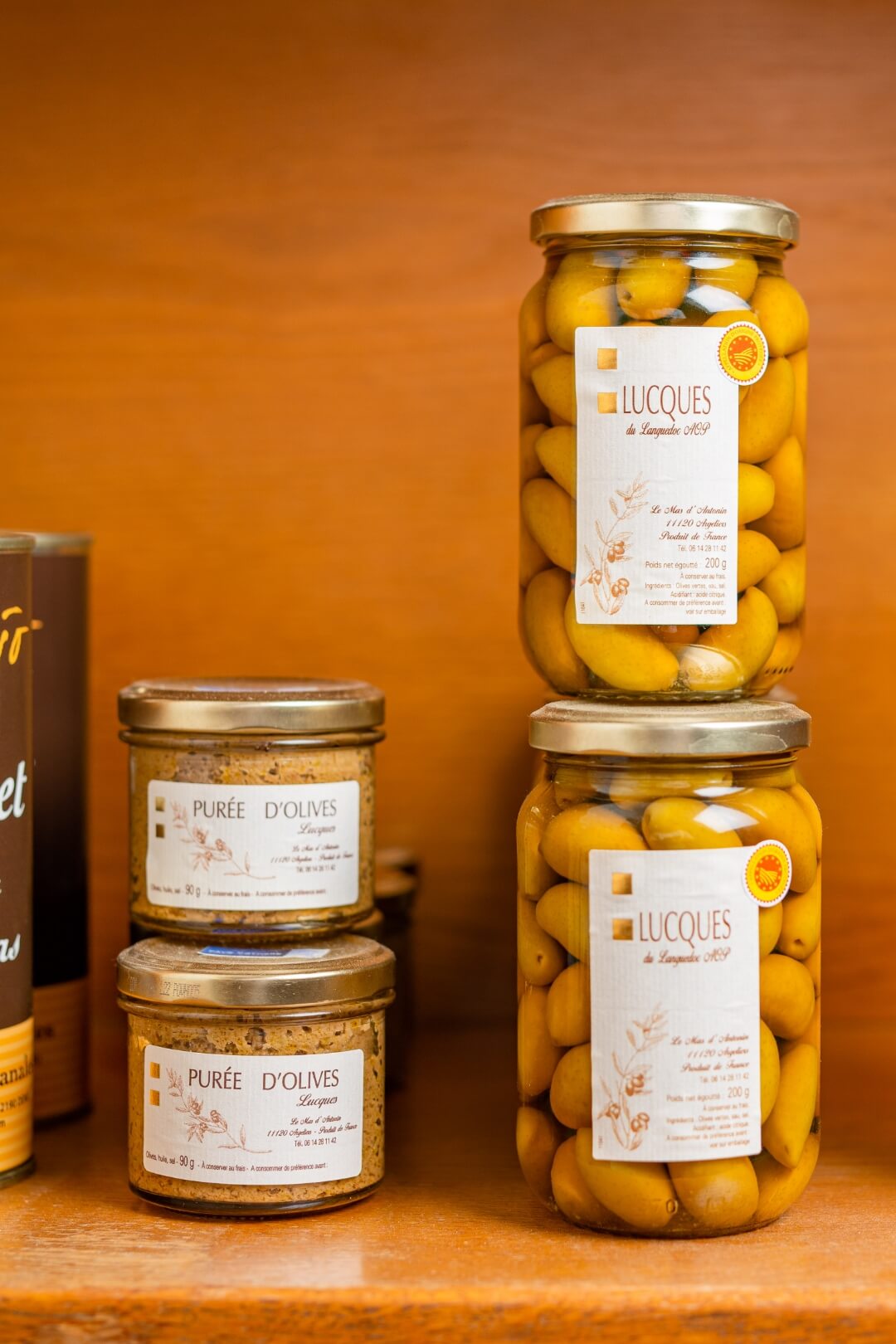 Bocaux d'olives et lucques proposés dans l'épicerie fine de la cave à manger de Sète Bouteilles à la mer.