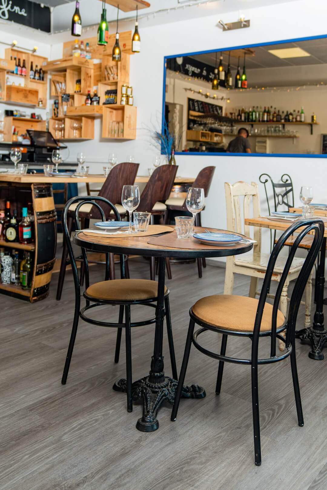 Salle cosy et chaleureuse du restaurant, cave et bar à vins, bouteilles à la mer.